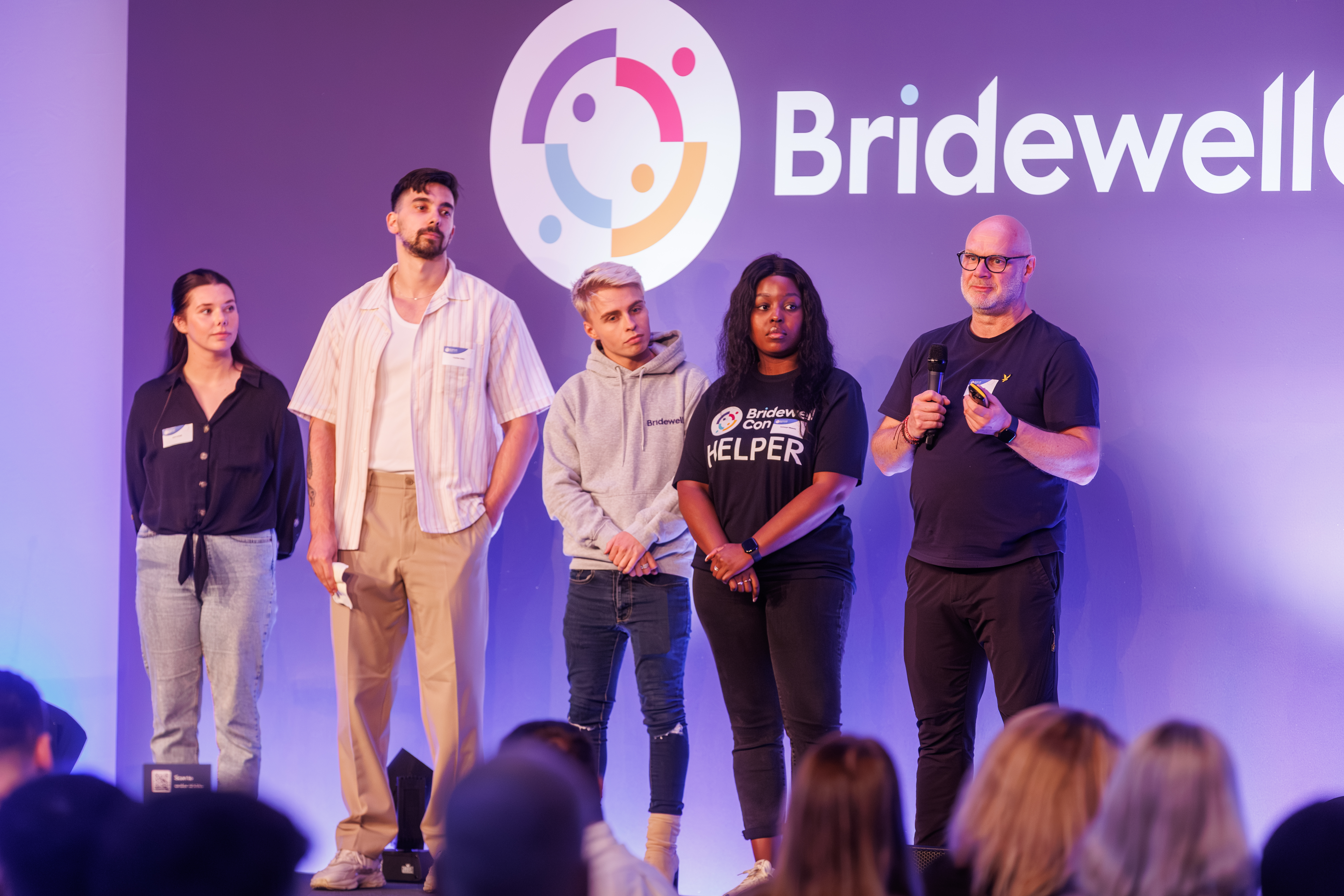 Five people speaking on stage