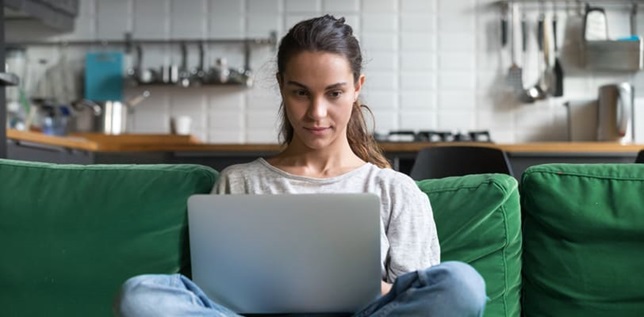 Women using laptop on sofa