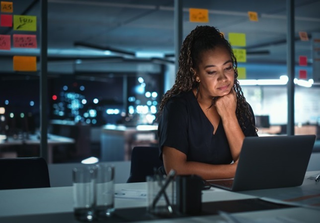 woman in office looking at laptop screen