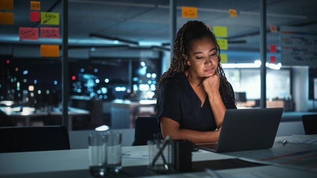 woman in office looking at laptop screen