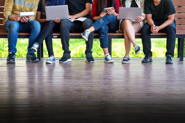 5 People chilling on bench with laptop