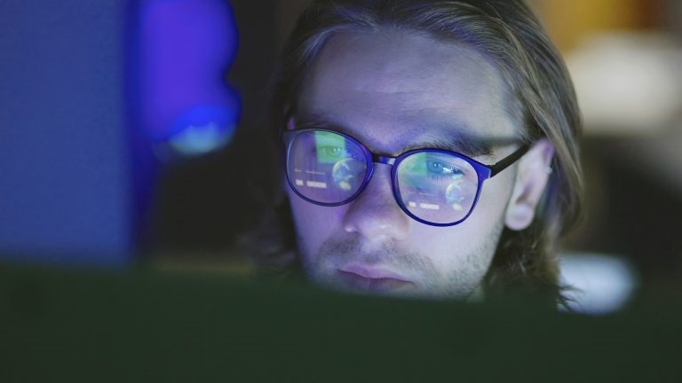 woman in office looking at laptop screen