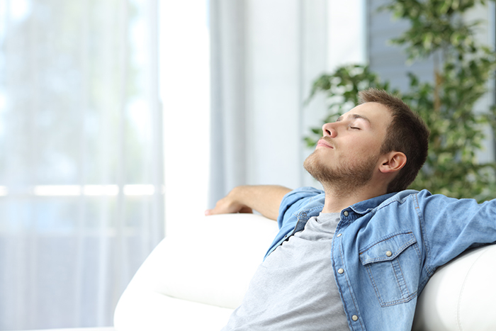 wellbeing man relaxing on sofa practicing mindfulness