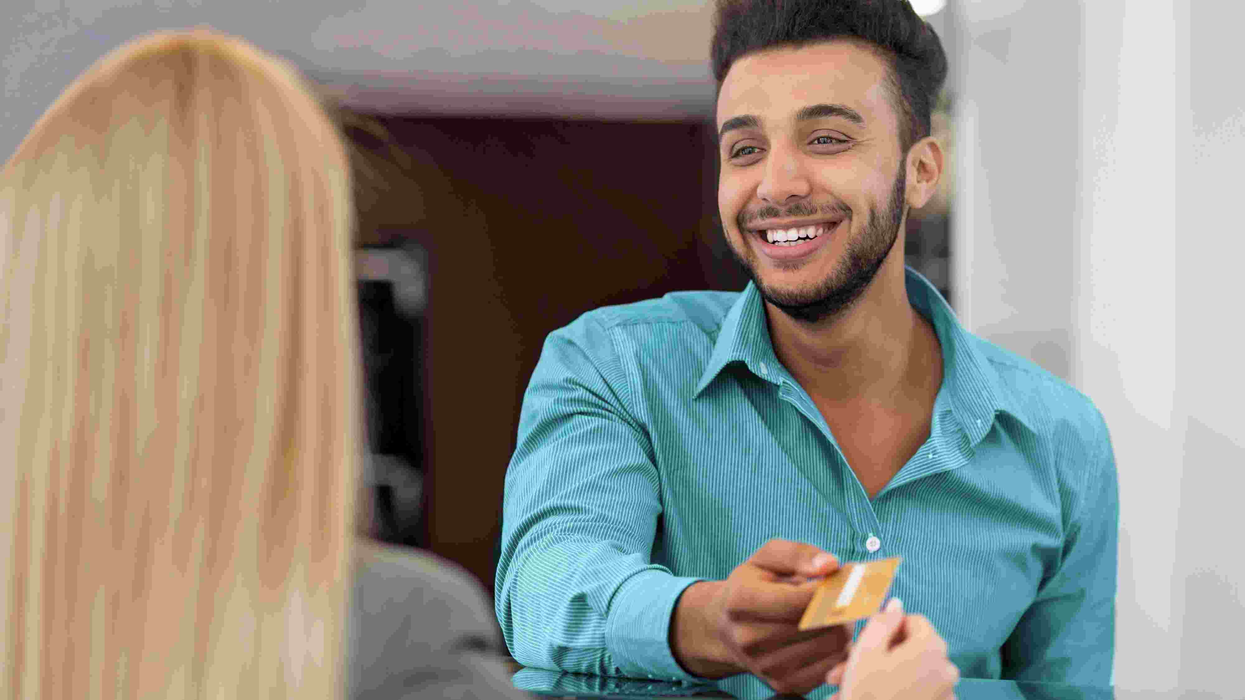 Young man handing over credit card Young man handing over credit card