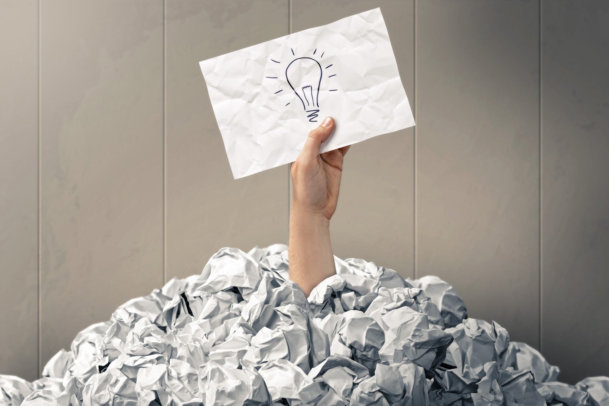 a light bulb found above piles of paper rubbish