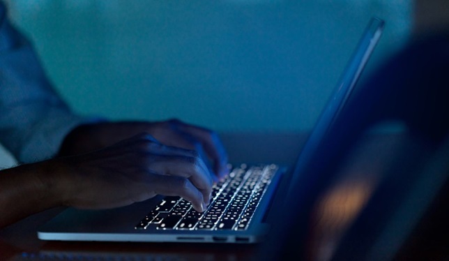 man typing on laptop